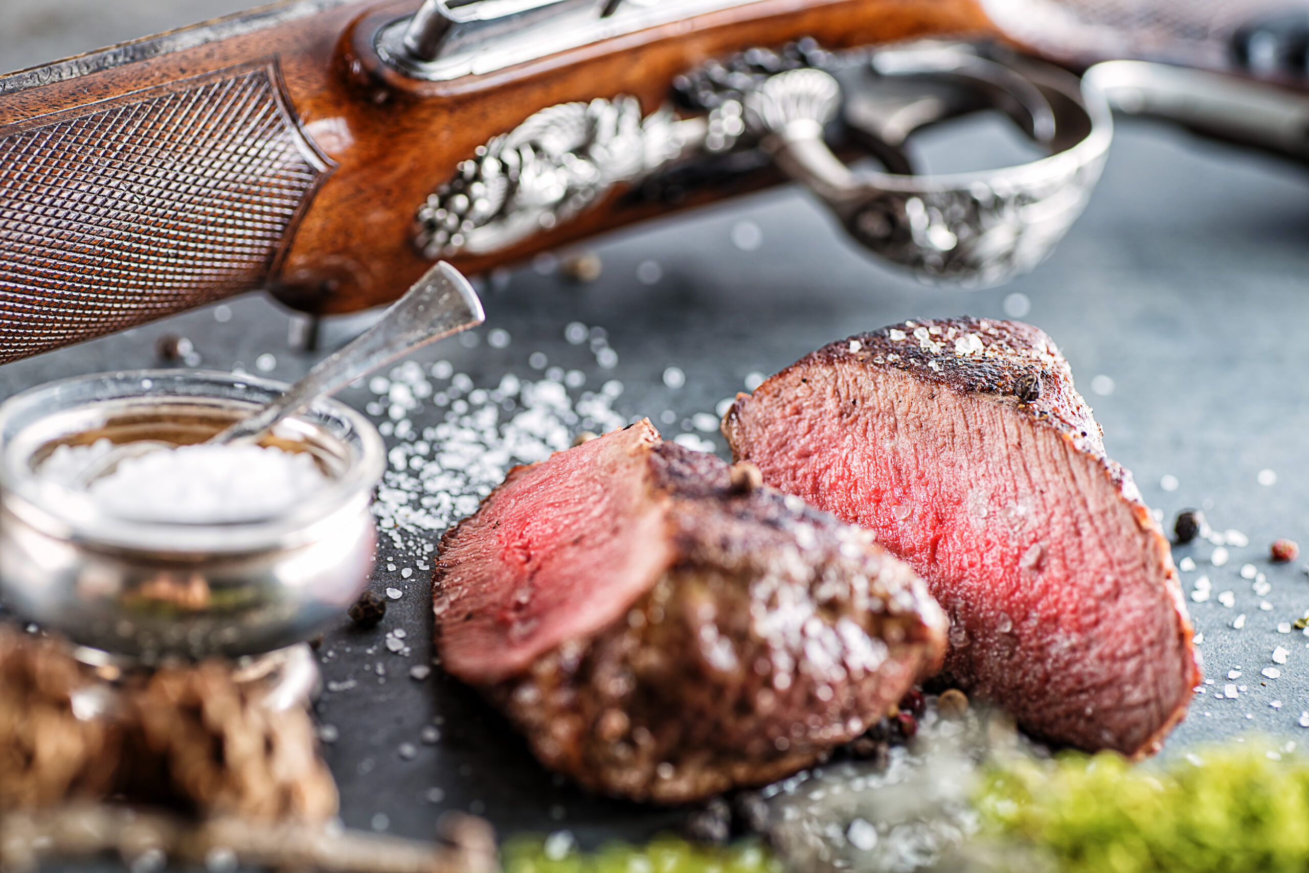 deer or venison steak with antique long gun and ingredients like