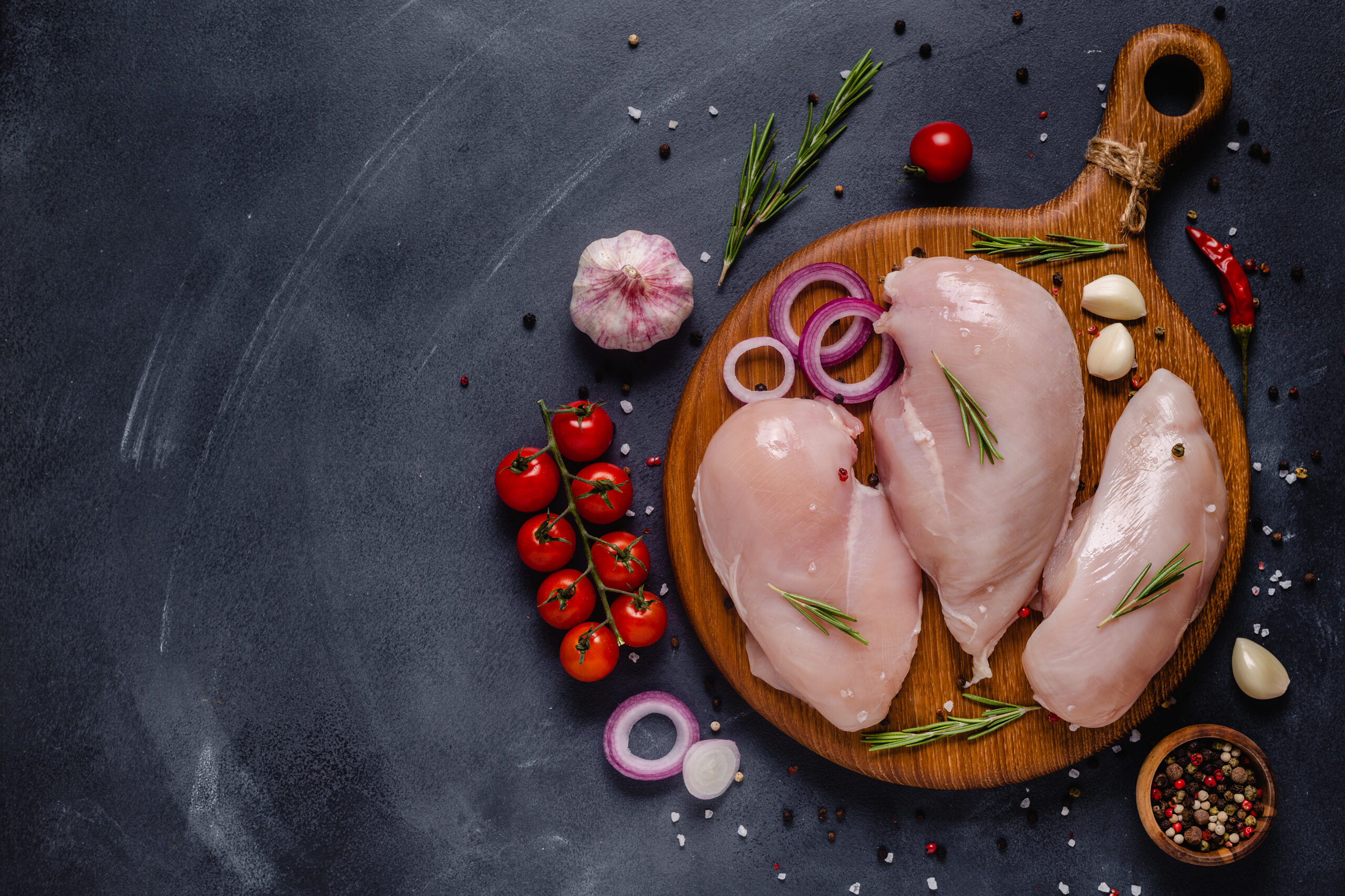 Raw chicken fillet with spices and herbs, top view.